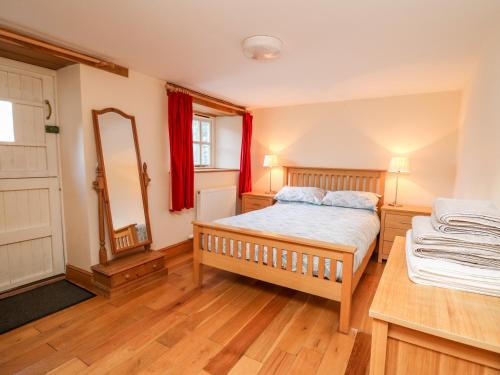 a bedroom with a bed and a mirror at The Stable in Lampeter