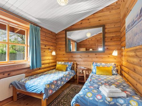 HighamptonにあるButtercupsの木造キャビン内のベッドルーム1室(ベッド2台付)