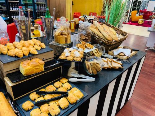 a buffet with various types of bread and pastries at Grand Hôtel de Nîmes 4 étoiles in Nîmes