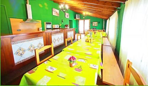uma sala de jantar com uma mesa longa com mesas amarelas em 7 bedrooms house with furnished terrace and wifi at Gamiz Fica em Fica