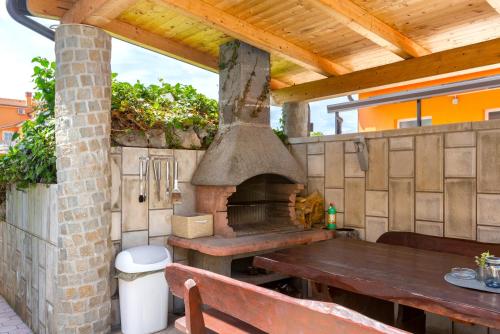 uma cozinha exterior com um forno de pizza e uma mesa em Villa Marko em Medulin