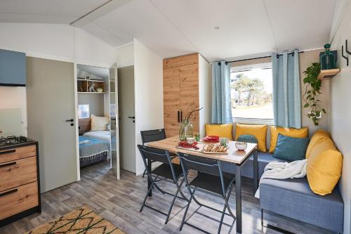 - un salon avec une table et un canapé dans l'établissement Camping Campéole Plage Sud - Maeva, à Biscarrosse