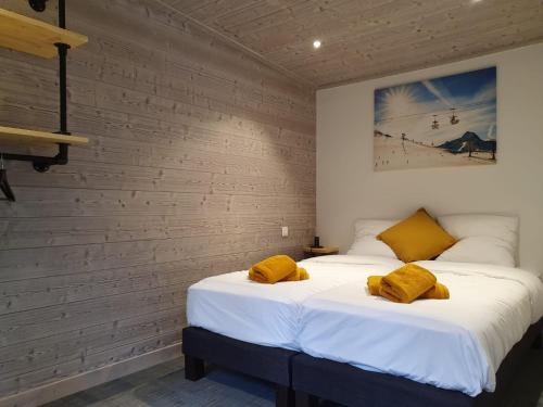 a bedroom with two beds with yellow pillows on them at Lodge Les Merisiers in Courchevel