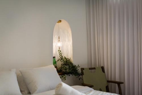 a bedroom with a bed and a chair and a window at Daya - Old City Acre in ‘Akko