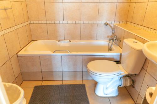un baño con inodoro y bañera en L'escalier Cabanas 107, en Amanzimtoti