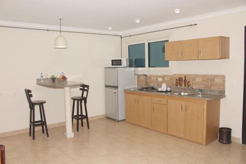 a kitchen with a refrigerator and a table and chairs at Dokki Apartments in Cairo