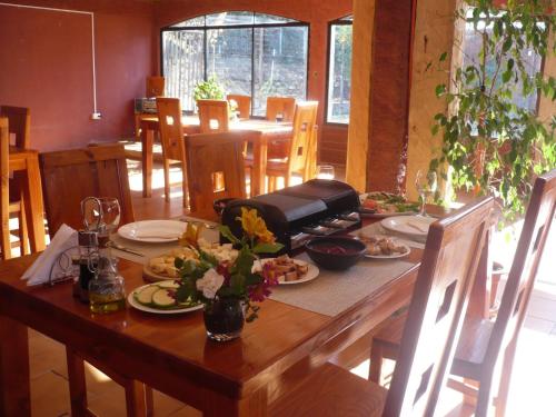 una mesa de madera con platos de comida. en El Parador de Caleu, en Tiltil
