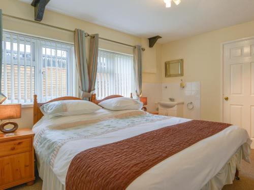 Un dormitorio con una cama grande y una ventana en Broadclyst Cottage en Exeter