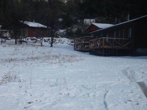 a snow covered yard with a house and a building at El Parador de Caleu in Tiltil