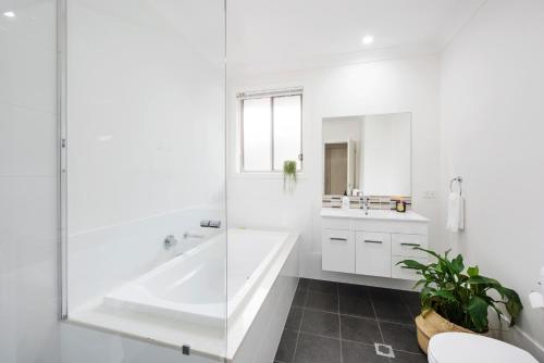 a white bathroom with a tub and a sink at The Willows in Mudgee