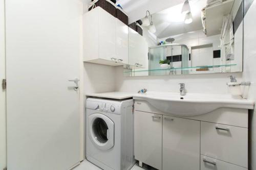 biała łazienka z pralką i umywalką w obiekcie Apartment Heart of Zagreb w Zagrzebiu
