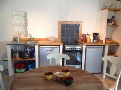 a kitchen with a wooden table and a kitchen with appliances at Mymoustiers in Moustiers-Sainte-Marie