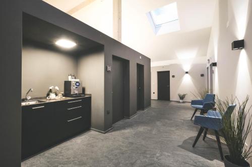 a room with a hallway with a sink and chairs at Frutigresort in Frutigen