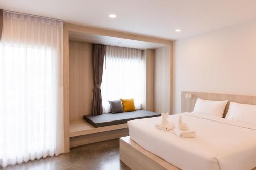 a bedroom with two beds and a window at Nappiness Hotel - SHA ExtraPlus in Bangkok