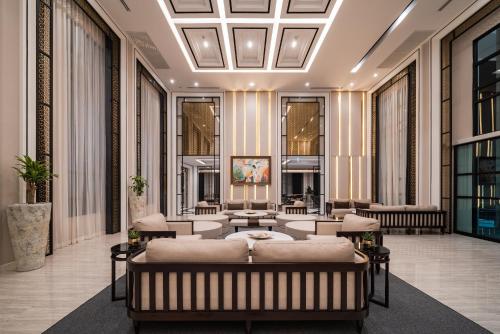 a lobby with a couch and tables and windows at Mandarin Eastville, Pattaya - SHA Extra Plus in Pattaya North