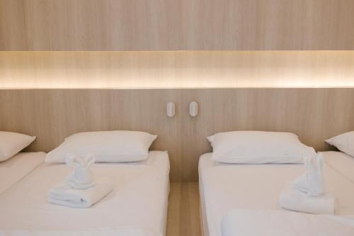 two beds in a room with white sheets and pillows at Nappiness Hotel - SHA ExtraPlus in Bangkok