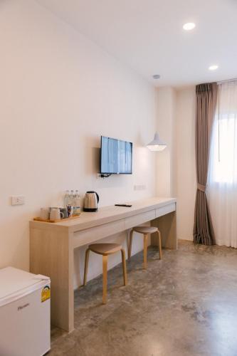 a kitchen with a desk and two stools at Nappiness Hotel - SHA ExtraPlus in Bangkok