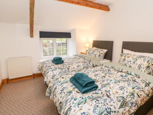 a bedroom with two beds with green towels on them at Bolt's View in Bishop Auckland