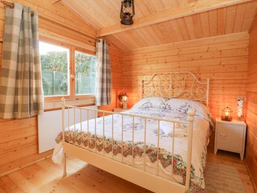 a bedroom with a bed in a log cabin at Beckside Lodge in Malton