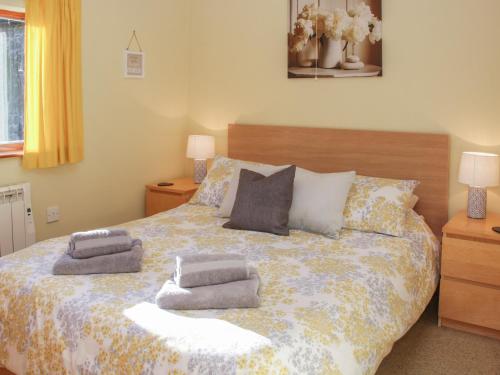 a bedroom with a large bed with pillows on it at Cranberry Cottage in Shrewsbury