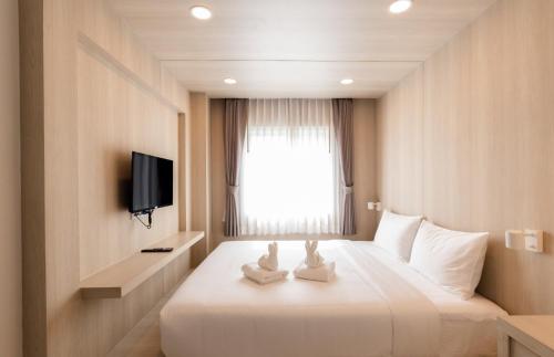 a hotel room with a bed and a television at Nappiness Hotel - SHA ExtraPlus in Bangkok