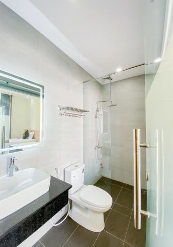 a white bathroom with a toilet and a sink at ZELDA hotel in Xã Thang Tam