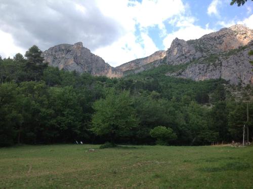 a field with trees and mountains in the background at Mymoustiers in Moustiers-Sainte-Marie