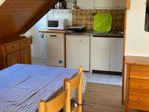 une petite cuisine avec une table et un micro-ondes dans l'établissement 33 Boulevard Charles de Gaulle, à Luchon