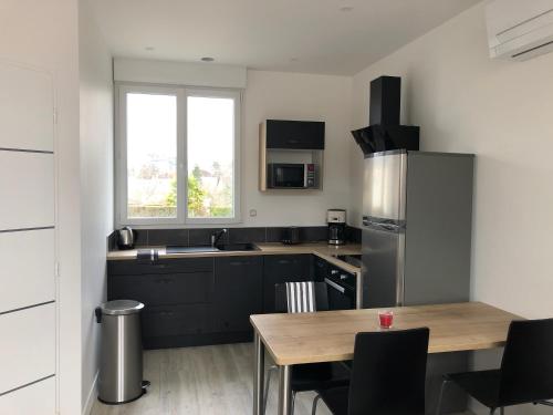 Il comprend une cuisine équipée d'une table et d'un réfrigérateur. dans l'établissement La Grange Lucien, à Saint-Avertin