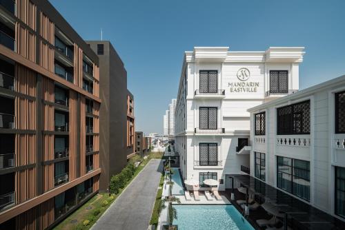 an apartment building with a swimming pool between two buildings at Mandarin Eastville, Pattaya - SHA Extra Plus in Pattaya North