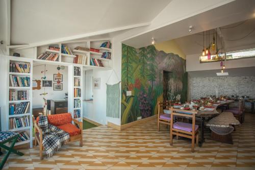 a dining room with a table and chairs and a painting at Seclude Mussoorie in Mussoorie