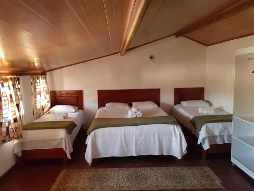 a bedroom with two beds with white sheets at Pousada Sempreviva in Rio de Contas