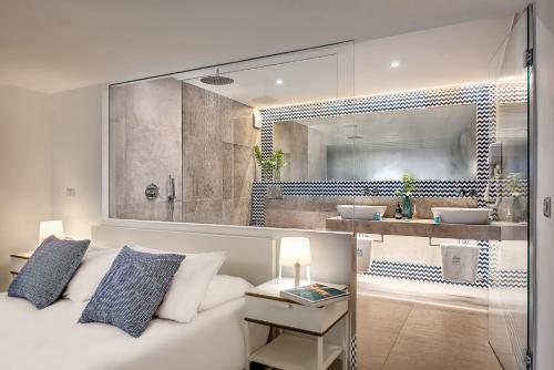 um quarto com uma cama branca e uma casa de banho em Gocce Di Capri Resort em Massa Lubrense