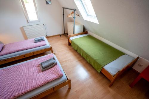 a room with three beds in a room at Black Forest Bike Hostel in Kirchzarten