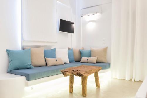 a living room filled with furniture and a tv at Anna Platanou Suites in Agia Irini Paros