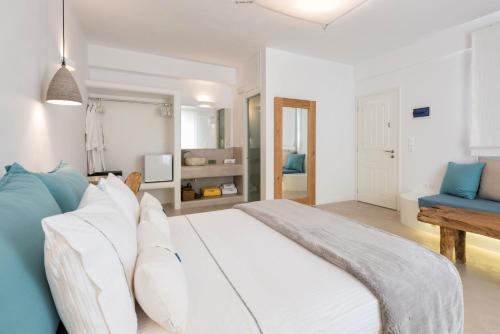 a bedroom with a white bed and a blue couch at Anna Platanou Suites in Agia Irini Paros