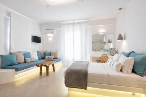 a bedroom with a large bed and a couch at Anna Platanou Suites in Agia Irini Paros
