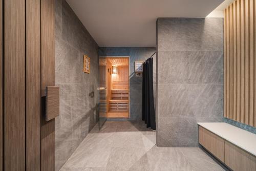 a bathroom with a walk in shower next to a door at Mandarin Eastville, Pattaya - SHA Extra Plus in Pattaya North