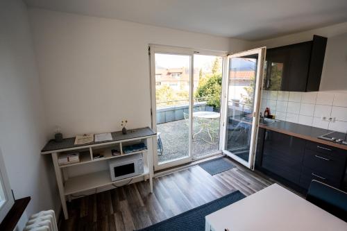 a small kitchen with a view of a balcony at Black Forest Bike Hostel in Kirchzarten