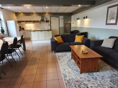 sala de estar con sofá y mesa en Hoeve Cobelli, en Noorbeek