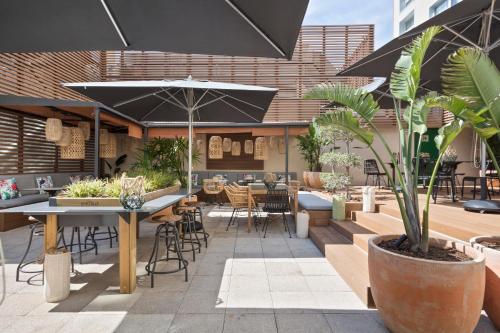 a patio with tables and chairs and an umbrella at INNSiDE by Meliá Barcelona Apolo in Barcelona