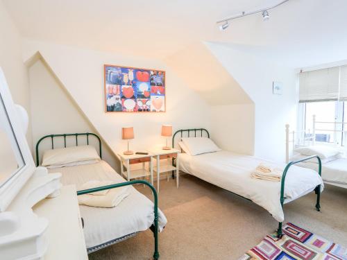 a room with two beds and a table at 2 North Crest House in Salcombe