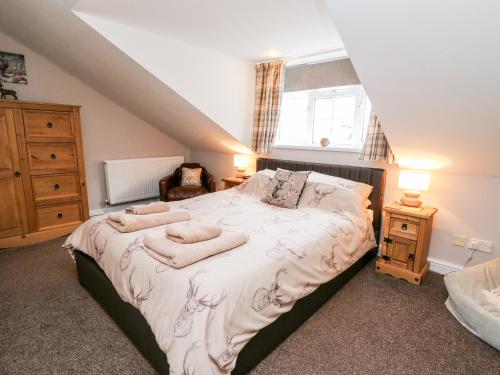 a bedroom with a bed with towels on it at Fisher Granary in Lampeter