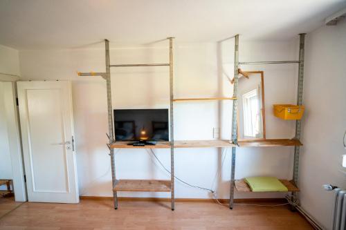 a room with shelves and a tv in a room at Black Forest Bike Hostel in Kirchzarten