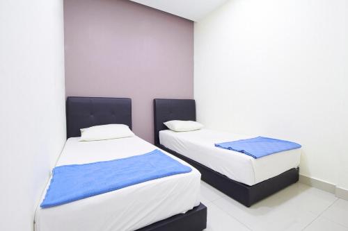 two beds in a room with white walls at Hotel 3Winz, Chow Kit Hospital Kuala Lumpur in Kuala Lumpur