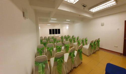 a room with rows of chairs with green bows at BASE HOTEL in Kuala Kubu Bharu