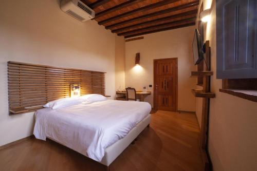 a bedroom with a large white bed and a desk at Agriturismo Cascina Farisengo in Stagno Lombardo