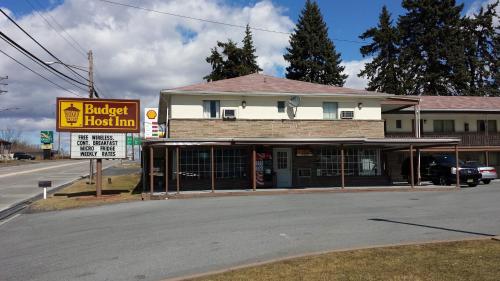 a building on the corner of a street with a truck inn at Budget Host Inn in Bedford