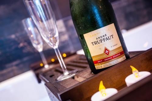une bouteille de vin posée sur une table avec des verres dans l'établissement LOVE ROOM - SPECIAL AMOUREUX - HYPER CENTRE - Lorient, à Lorient
