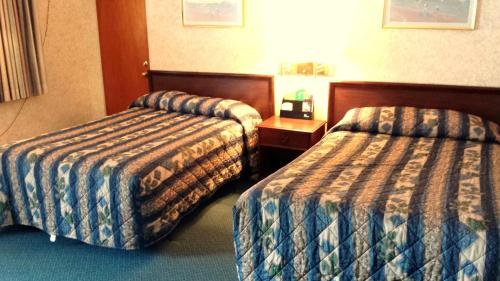 a hotel room with two beds in a room at Budget Host Inn in Bedford